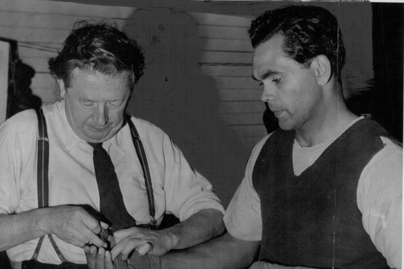 Trainer Tom Maguire adjusts Dave Sands' tapes before a workout at Newcastle prior to the Stadium bout with American Henry Brimm, August 3, 1950.