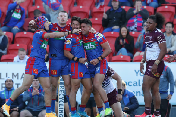 Newcastle players celebrate a try, much to the disdain of their Manly counterparts.