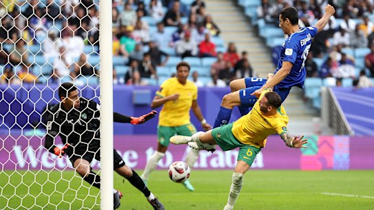 Martin Boyle shoots whilst under pressure from Umar Eshmurodov of Uzbekistan.