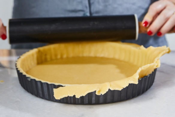 Cut off the excess pastry by running a rolling pin over the tart tin.