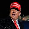 President Donald Trump speaks to reporters in the rain after arriving at Joint Base Andrews in Maryland on Friday.