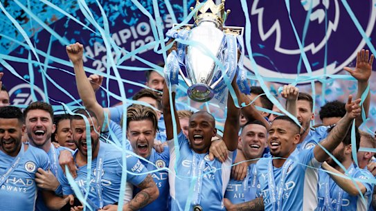 Manchester City players celebrate with the 2022 Premier League trophy.