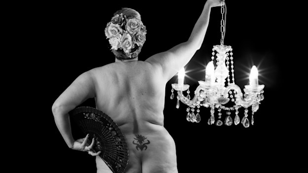 “At this age I am in my glory. I hold a lit chandelier because they throw glory. The fan is for hot flushes, the tattoo reflects making my mark and the flowers for a head and heart full of bloomings.”