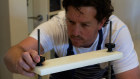 Grant Orchard sets his cheese press. Cheeses that are harder or drier typically have had more whey removed from the curds through extra stirring and then applying pressure using a cheese press.