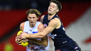 Lachie Whitfield is tackled by Josh Honey.