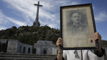 A visitor holds a portrait of former Spanish dictator Francisco Franco at the Valley of the Fallen mausoleum.