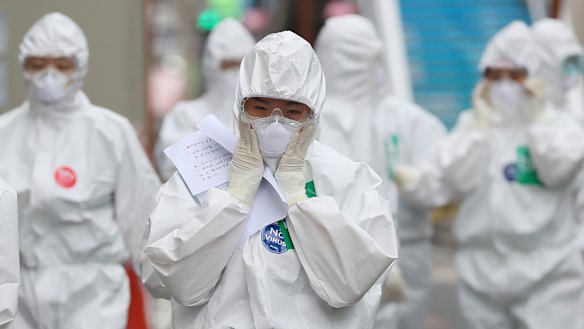 A medical staff member adjusts her face mask as she arrives to start work at Dongsan Medical Centre in Daegu, South Korea.