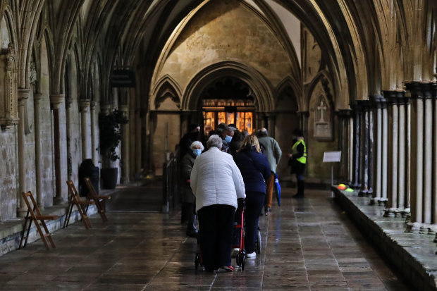 People queue for the vaccine in the cathedral’s 13th century cloisters. 