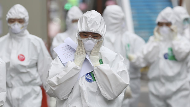 A medical staff member adjusts her face mask as she arrives to start work at Dongsan Medical Centre in Daegu, South Korea.