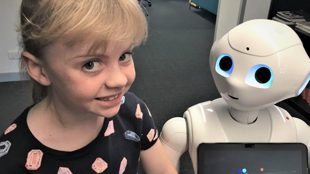 Ella, 7, and Pepper the Robot, at the Australian Centre for Robotic Vision.