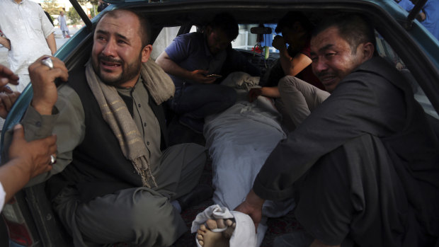 The body of a man is taken away for burial after the bombing in western Kabul. 