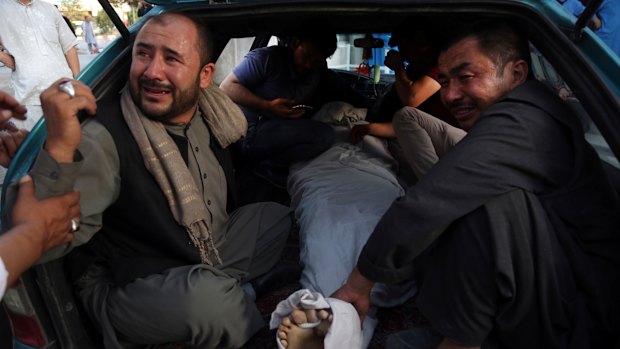 The body of a man is taken away for burial after the bombing in western Kabul. 