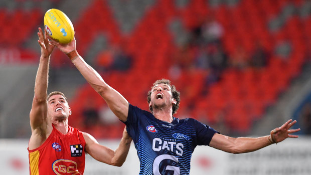 Tap and go: Gold Coast's Zac Smith (left) takes on Darcy Fort of the Cats.