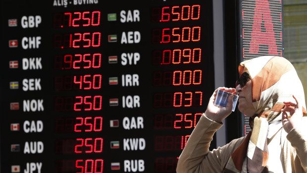 A woman checks the rates at a currency exchange shop in Istanbul. 