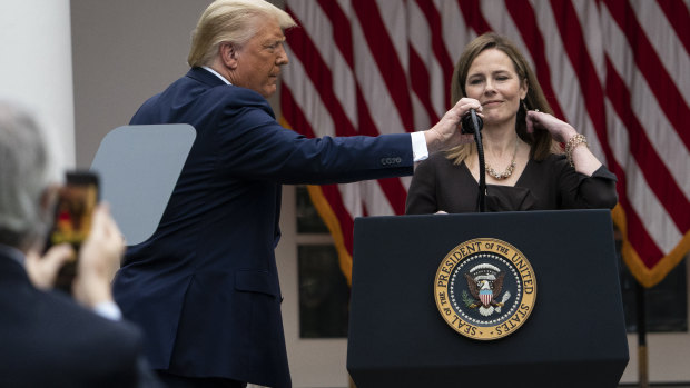 President Donald Trump adjusts the microphone as he announces Judge Amy Coney Barrett as his nominee to the Supreme Court.