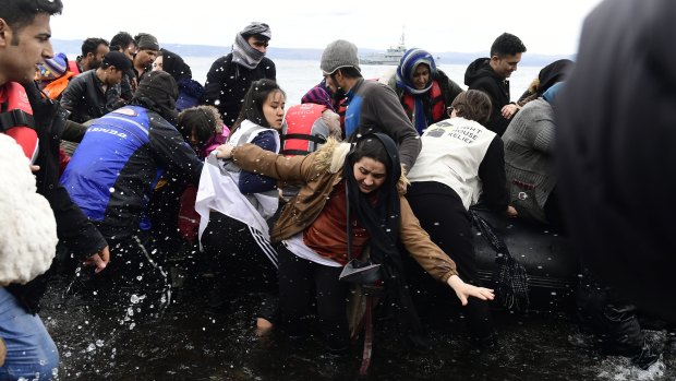 Migrants arrive on a dinghy at the village of Skala Sikaminias, on the Greek island of Lesbos, after crossing the Aegean sea from Turkey.