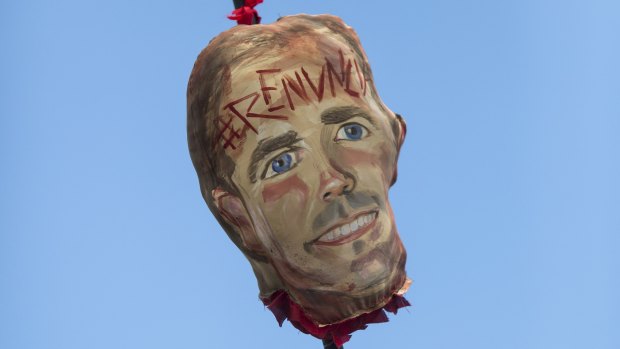 Demonstrators carry a image representing the head of Governor Ricardo Rossello on a pike, with an inscription on its forehead that reads in Spanish "Resign" during a march demanding the resignation of Governor Rossello, in San Juan.