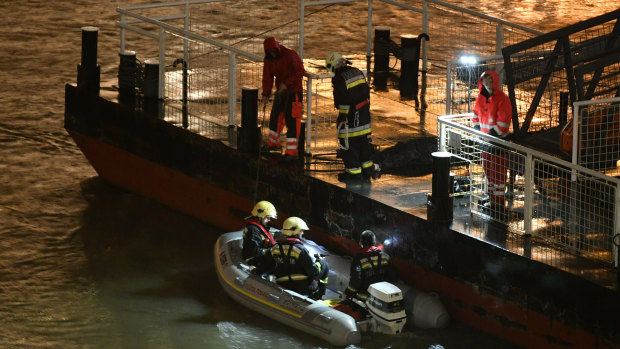 Responders sit in a rubber dinghy preparing for the search for victims.
