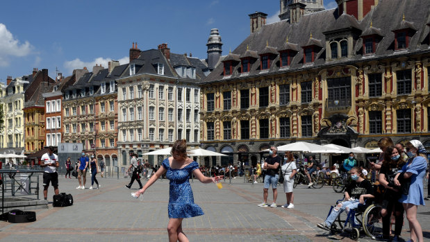 A woman dances by a cafe terrace in Lille, northern France. 