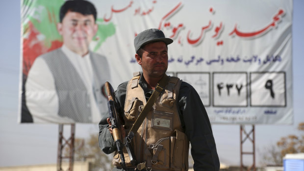 Afghan police stand guard at a checkpoint ahead of parliamentary elections scheduled for October 20.