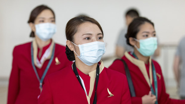 People wearing face masks to protect themselves from coronavirus are seen at Brisbane International Airport.