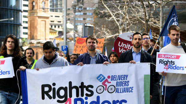 Protestors hold placards during a delivery drivers rally ahead of a Foodora creditors meeting in Sydney.