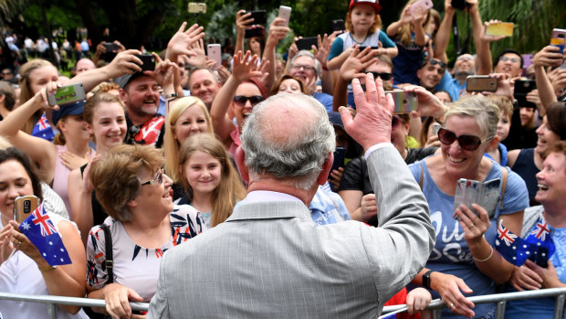 Prince Charles waves to cheering members of the public during a public walk through the Brisbane City Botanic Gardens.