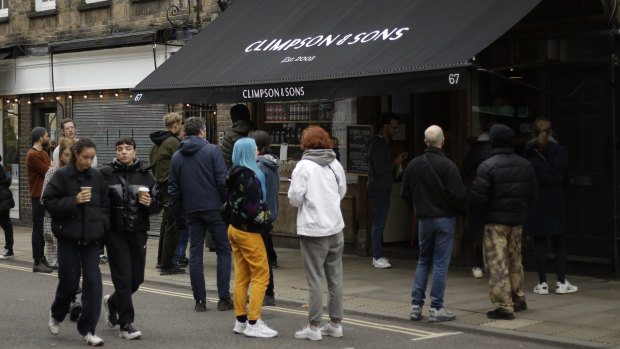 People queue up for their takeaway orders outside the Climpson & Sons speciality coffee in Hackney, east London, during lockdown.