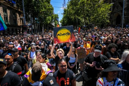 Protesters gather at the intersection of Flinders and Swanston streets to mark Invasion Day.