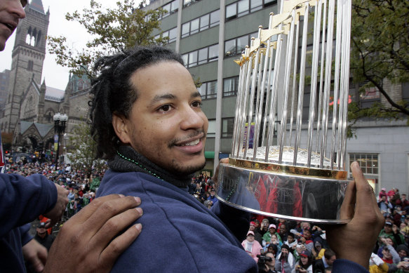 Manny Ramirez shows off Boston’s World Series trophy after their drought-breaking 2004 win.