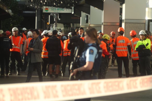 İnşaat işçileri, Auckland'ın CBD'sinde polisin olaya müdahalesini izliyor.