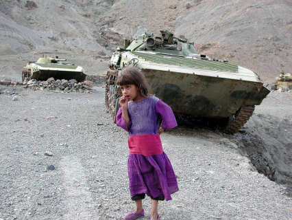 An Afghan girl stands near some armoured vehicles left behind by the Soviet Army in the ’80s.