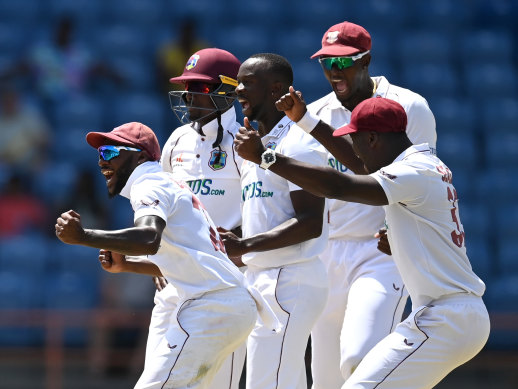 West Indies quick Kemar Roach celebrates with teammates after the dismissal of Jack Leach.