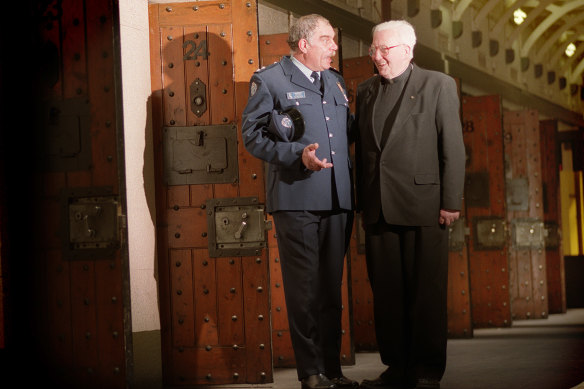 Senior prison officer Ian Burchett chats with former prison chaplain Father Brosnan in the now closed D Division.