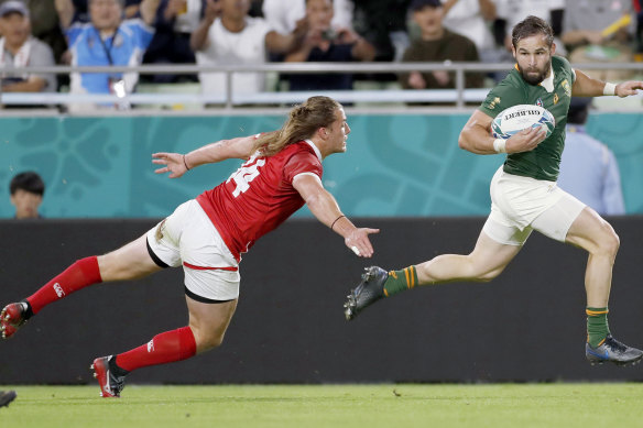 South Africa's Cobus Reinach runs clear of Canada's Jeff Hassler during the Rugby World Cup Pool B game at Kobe Misaki Stadium.