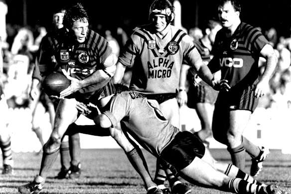 Mark Graham stands in a tackle by Balmain skipper Wayne Pearce in 1987.