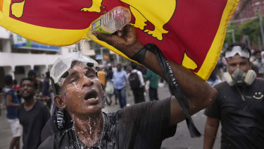 A protester washes his eyes to avoid tear gas effect during a protest in Colombo this month.
