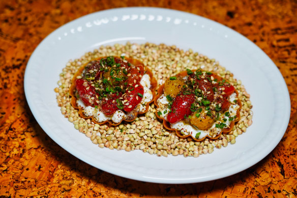 A tart featuring confit cherry tomatoes on a cloud-like base of whipped ricotta.