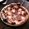 Salmino piccante pizza with with tomato sugo, mozzarella, spicy salami and kalamata olives.
