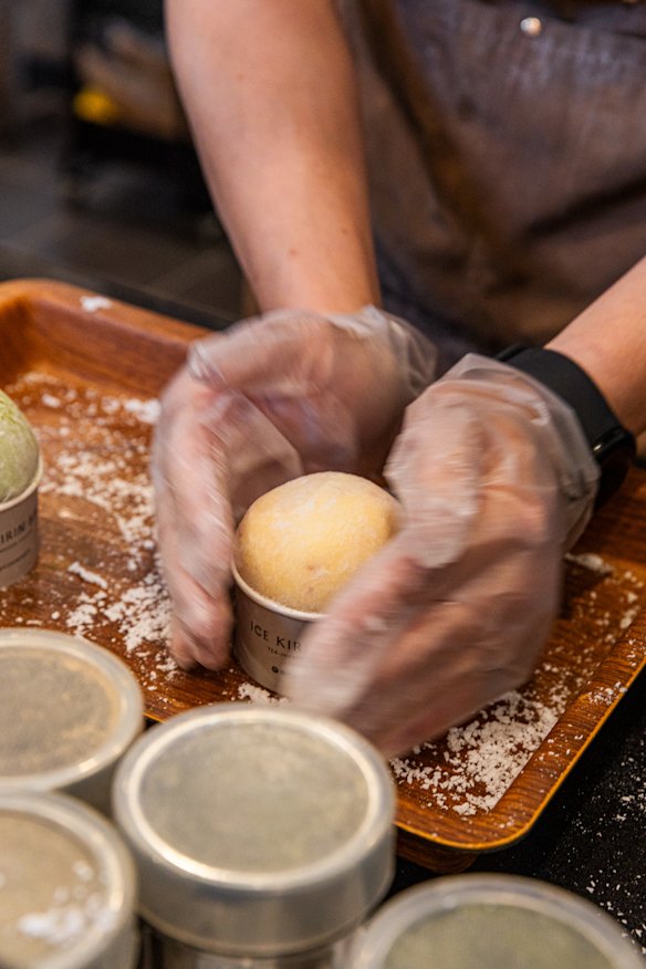 Mochi being stretched over the gelato.