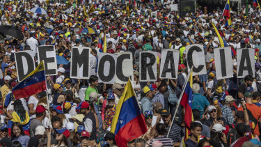 Demonstrators hold signs spelling "Democracia" during a pro-opposition protest in Caracas on  Saturday.