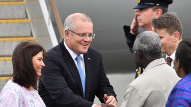 Prime Minister Scott Morrison and his wife Jenny greet Solomon Islands Prime Minister Manasseh Sogavare (right) after arriving in the Solomon Islands on Sunday.