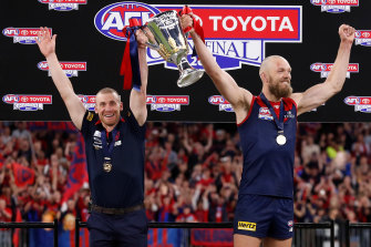 Melbourne coach Simon Goodwin and captain Max Gawn stand euphorically with premiership cup in-hand.