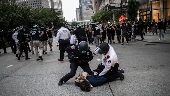 Police arresting protesters refusing to get off the streets during an imposed curfew in New York. 