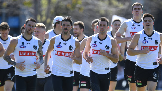 Hot Pies: Captain Scott Pendlebury leads his players on a warm-up lap at Olympic Park Oval.