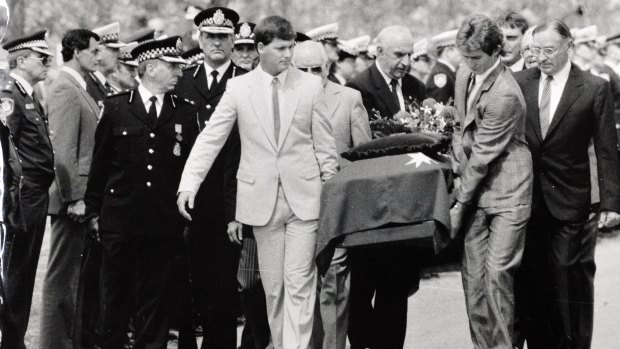 The coffin of Assistant Police Commissioner Colin Winchester is carried by pall-bearers and flanked by police at his funeral, 13 January, 1989.
