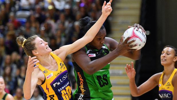 Fever's Jhaniele Fowler (centre) grabs the ball as Karla Pretorius of the Lightning (left) defends earlier in the season.