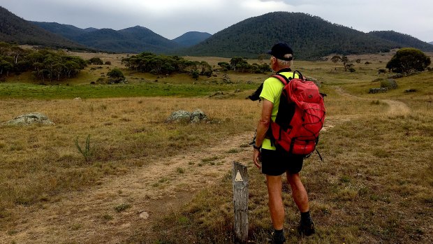 John Evans looks towards the distant horizon and his three favourite peaks in Namadgi National Park – Mt Kelly, Mt Burbidge and Mt Namadgi.
