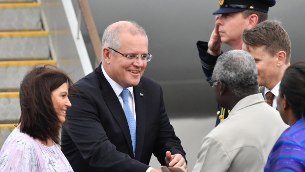 Prime Minister Scott Morrison and his wife Jenny greet Solomon Islands Prime Minister Manasseh Sogavare (right) after arriving in the Solomon Islands on Sunday.