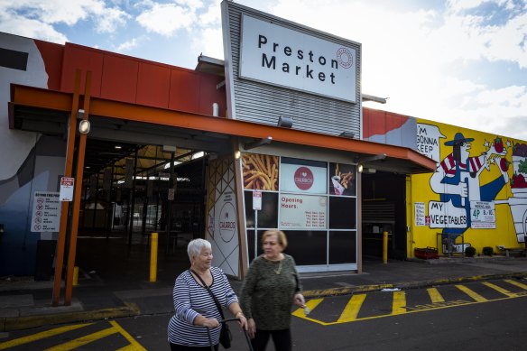 Shoppers leave Preston Market on Monday.